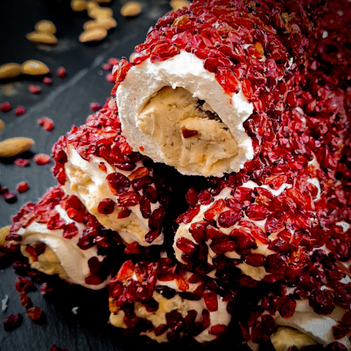 Piena-vaniļas lukums ar maigu mandeļu krēmu, pārkaisīts ar granātābola sēklām