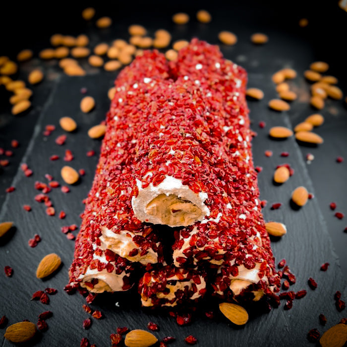 Piena-vaniļas lukums ar maigu mandeļu krēmu, pārkaisīts ar granātābola sēklām